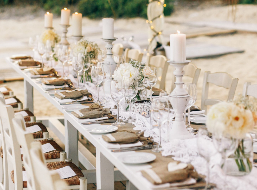 long-dinner-table-decorated-with-flaxen-cloth-white-candles-scaled